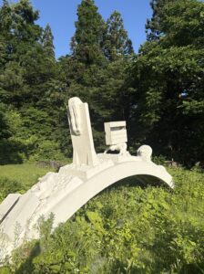 「人生のアーチ」白いアーチと人の一生を表した像
