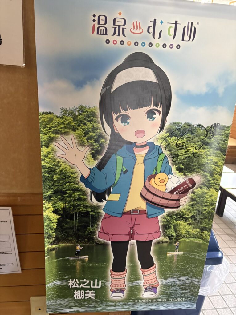 鷹の湯の館内に掲示された温泉むすめ「松之山棚美」のパネル。サインが入っている