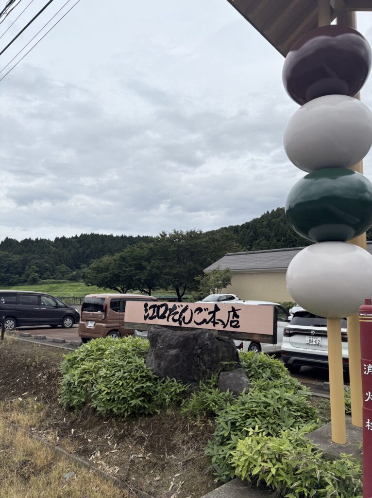 国道8号線沿いに立つ江口だんご本店の巨大な串団子モニュメントと看板