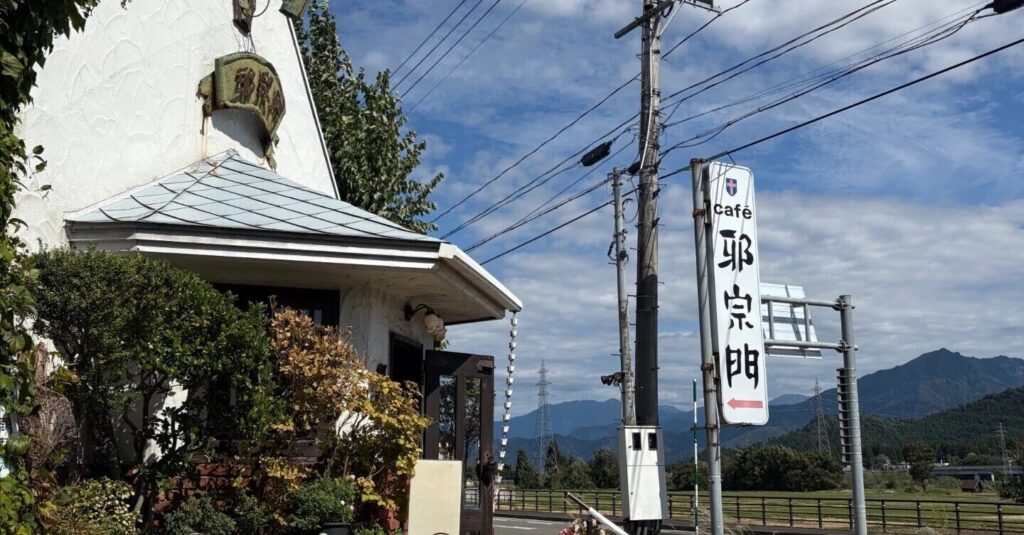 塩沢邪宗門の教会風の白い外観とcafé邪宗門の看板