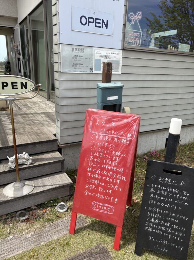 cloche店頭の赤い立て看板と黒板に書かれた手書きの案内