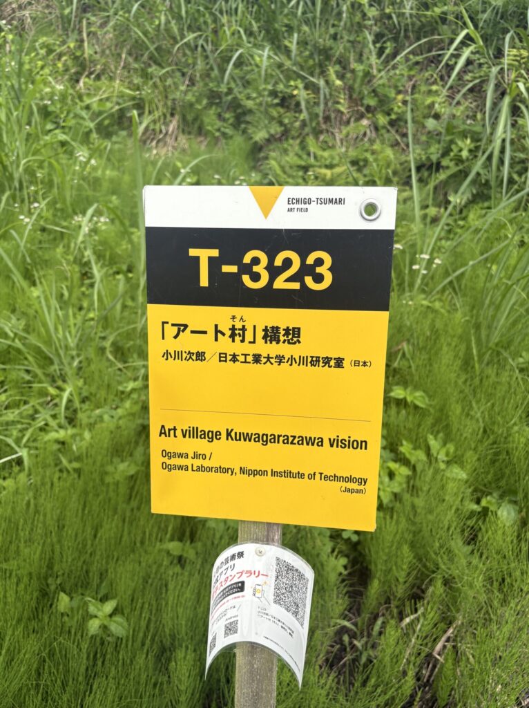 草むらに立つ「アート村（そん）・鍬柄沢」構想（T-323）の看板
