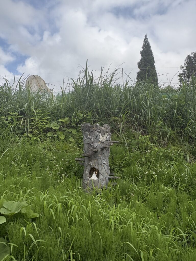 草の斜面にぽつんと立つ、「アート村（そん）・鍬柄沢」構想の小さな作品