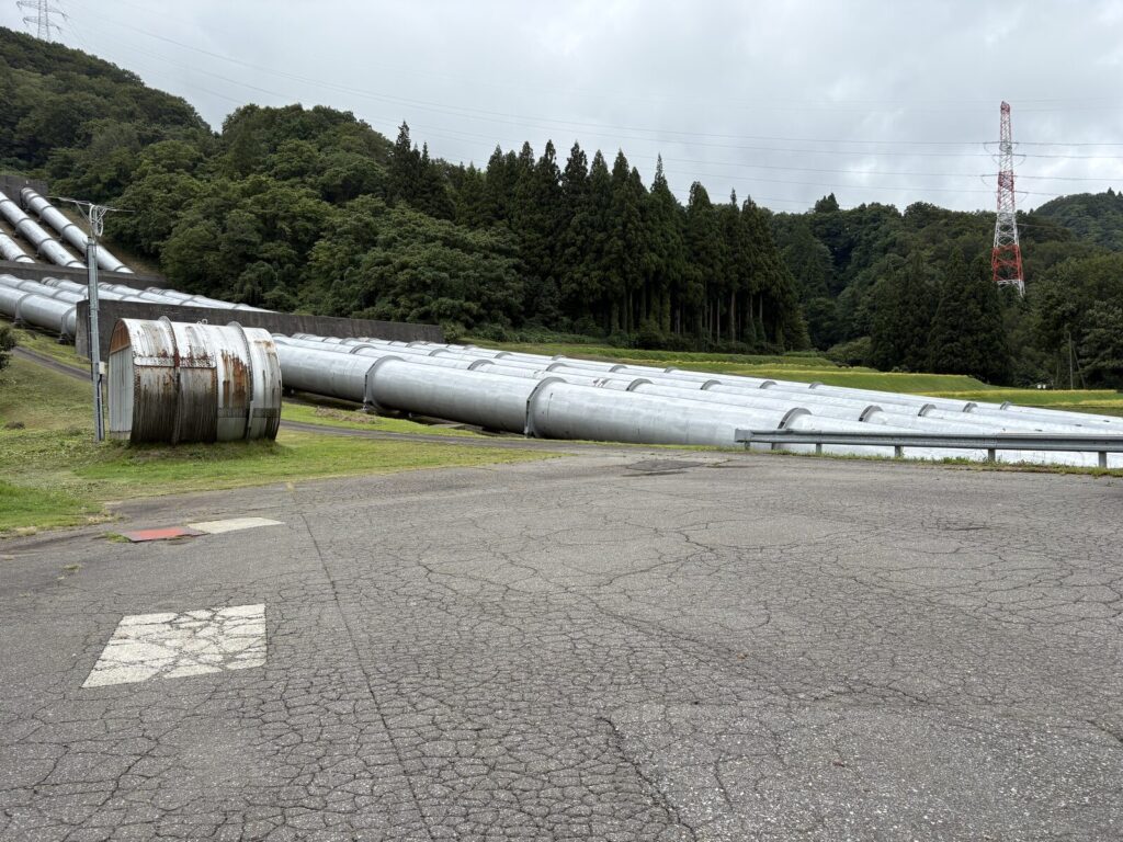 ヤナギヤの第二駐車場。奥に発電所の水圧鉄管が並ぶ